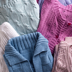 Fototapeta na wymiar Overhead view of folded handmade assorted sweater clothing. Homemade colorful knitted clothes background. Modern Sweater Jersey Apparel