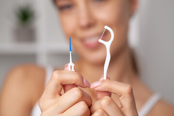 Woman using dental floss for cleaning her teeth