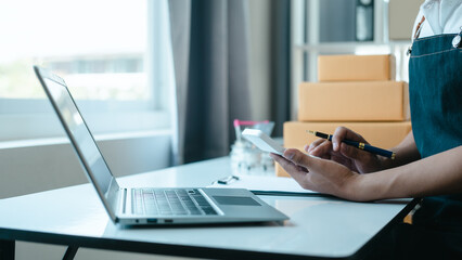 Asian business man seller freelancer prepares box for delivery to  customer in sme supply chain, warehouse.