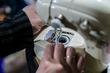 Hands of a mature woman on a sewing machine