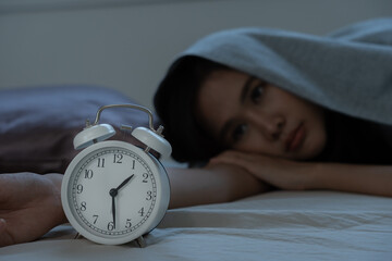 asian woman in bed late trying to sleep suffering insomnia, sleepless or scared in a nightmare,...