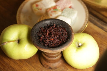 bowl with tobacco for hookah. shisha smoking. berries and fruits on a dark background.