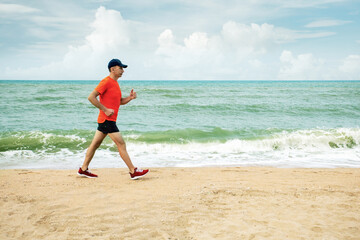 Active senior man running down sandy beach.  Healthy lifestyle. Jogging.