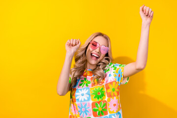 Photo excited pretty lady dancing summer youth party festival wear heart sunglass print shirt isolated yellow color background