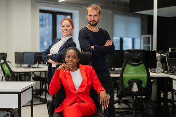 Caucasian redhead woman, bearded caucasian man and african american young woman in office. 