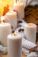 Fototapeta na wymiar Thanksgiving and Hello Fall Halloween concept Celebrating autumn holidays at cozy home on the windowsill Hygge aesthetic atmosphere Autumn leaves spices and candle on knitted white sweater in warm