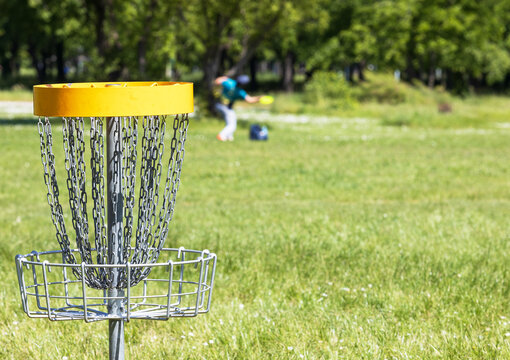 Disc golf player throwing a flying disc in the nature