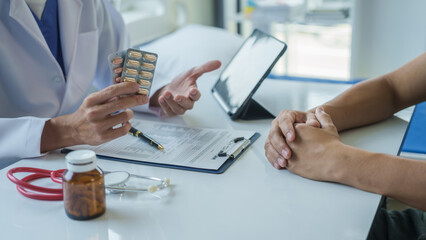 Male doctor is consulting with a young man about prostate cancer and venereal disease and sexual dysfunction about the causes of erectile dysfunction in an examination room.