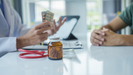 Male doctor is consulting with a young man about prostate cancer and venereal disease and sexual...