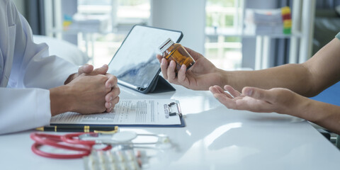 Male doctor is consulting with a young man about prostate cancer and venereal disease and sexual...