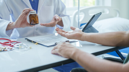 Male doctor is consulting with a young man about prostate cancer and venereal disease and sexual dysfunction about the causes of erectile dysfunction in an examination room.