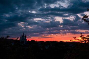 Silhouette of church temple against cloudy sunset sky.