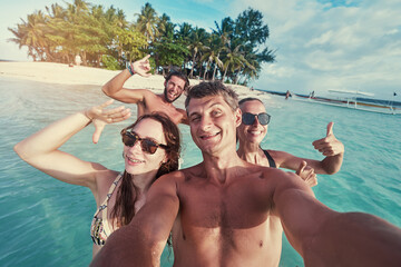Having fun on the beach together. Vacation with friends. Group of young people taking selfie on the...