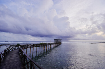 Fototapeta premium Beautiful landscape. Sunset on the seashore. Wooden bridge on Cloud Nine beach, Siargao Island Philippines.