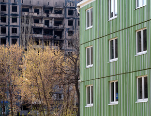 newly built house against the background of the destroyed and burned during the fighting in Ukraine