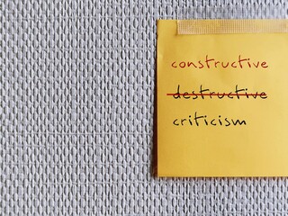 Note stick on copy space office wallpaper with handwritten DESTRUCTIVE CRITICISM, changed to CONSTRUCTIVE CRITICISM - means to shift focus on negative to be on building up other person - obrazy, fototapety, plakaty