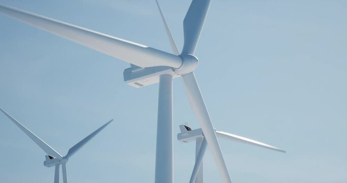 SEAMLESS LOOP Clean shot of 3 of wind turbines producing electricity against bright blue sky. Background for sustainable energy conference, website header