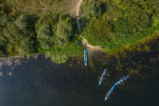 Kayaking and canoeing in the summer river. Aerial drone view on kayaks and river bank.