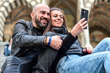  Happy smiling beautiful  Tourists  couple traveling in Italy poses and making photos near the...