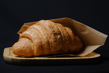 croissant in an envelope on a black background