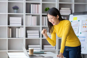 A young woman is a start-up businesswoman, she sits in the office and looks happy, manages and runs the business from the young generation. Startup business management concept.