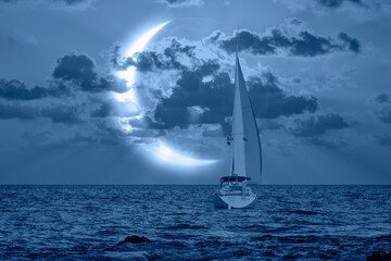 A lonely yacht sails on the sea,  Crescent or new moon  in the background 