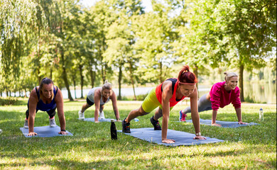 Group of women doing high plank exercise during outdoor fitness class.