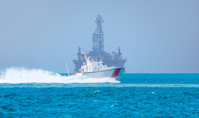 Coast Guard patrol boat rushing to the rescue - Oil and gas wellhead remote platform