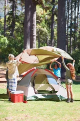 Foto auf Acrylglas Children, tent and camping setup in forest for shelter, cover together on the grass in nature. Happy kids in teamwork setting up tents for camp adventure or holiday vacation in the woods © Anne/peopleimages.com