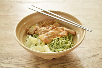 jade Chinese egg noodles topping Korean fried slice pork with cabbage dressing sauce on bowl  
