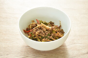 spicy stir fried bamboo shoot and chop beef meat with basil leaf in bowl
