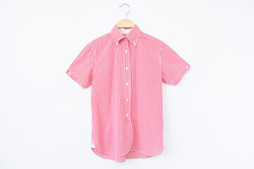 Pink blouse with hanger wooden on background.