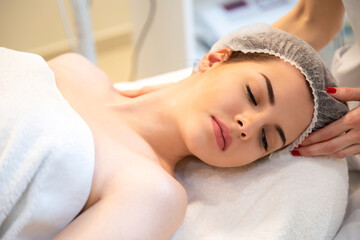 Fototapeta na wymiar Close up portrait of beautiful woman receiving facial massage at luxury spa