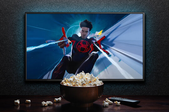 TV screen playing Spider-Man Across the Spider-Verse trailer or movie. TV with remote control and popcorn bowl. Astana, Kazakhstan - May 15, 2023.