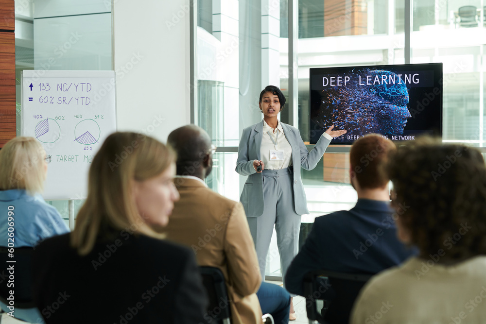 Poster confident young businesswoman in elegant suit making presentation of deep learning course while stan