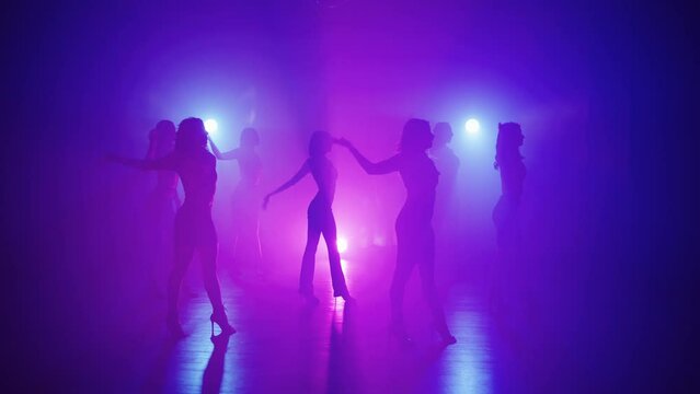 Exciting group dance on high heels in the rays of spotlights. A dance that helps to create a beautiful shape of the legs and keep them in good shape. High quality 4k footage