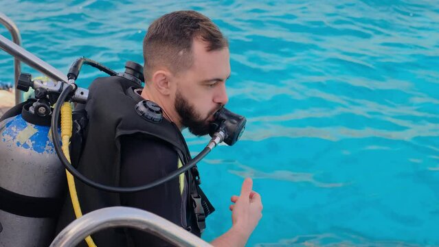 a man with scuba diving is sitting on board a yacht, preparing to dive, diving in the sea, an instructor teaches how to scuba dive, the process of learning to dive.