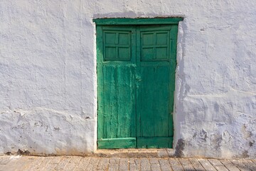 Image of an old Mediterranean green wooden door in a historic village