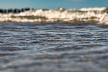 Seawater view with focus on the front of the water. Blurred background with low depth of field. Template on the theme of a seaside vacation with blank space for text.