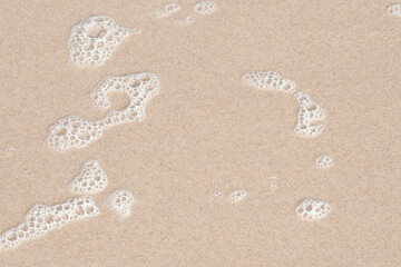A thin layer of clear water over the sand. A seaside or ecology-themed background with clear sea water over a sandy bottom.