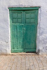 Image of an old Mediterranean green wooden door in a historic village