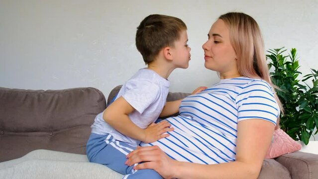 A pregnant woman hugs her eldest son. Selective focus.