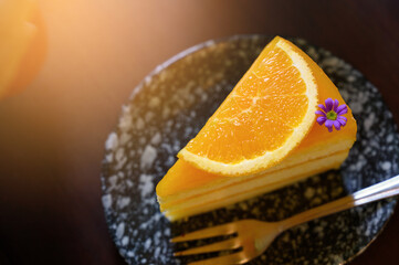 Top View of a piece of orange cake and sliced orange topping with spoon. Cake with orange mousse with copy space.