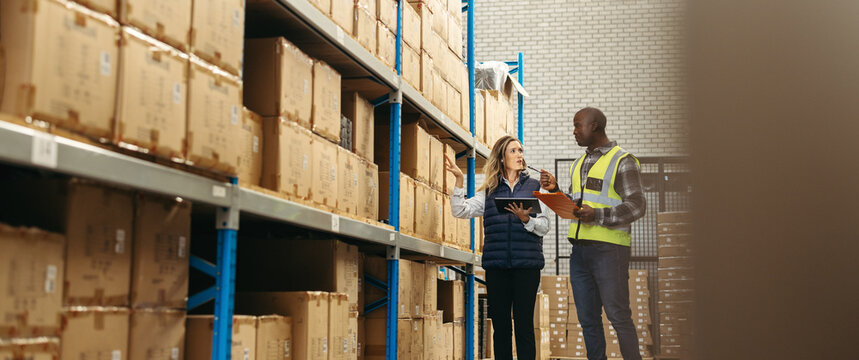 Warehouse workers recording inventory using warehousing technology