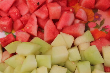 Assortment of healthy raw fruits and berries platter background, melons and mangoes