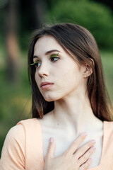 Naklejka premium Mindfulness Practices to Connect with Nature, relaxation breathing techniques. Outdoor portrait of calm young woman in nature background