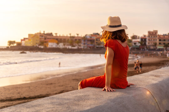 Tourist woman with hat at sunset on vacation on the beach of Valle Gran Rey village on La Gomera, Canary Islands