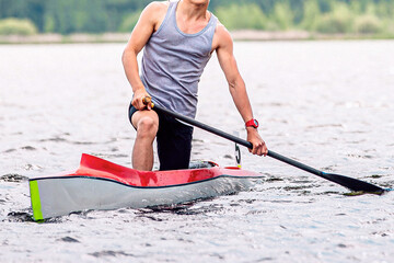 front view male athlete canoeist on canoe single, after finish line, paddle the water, summer...