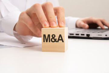 M and A text wooden block on white table background. Idea, strategy, advertising, marketing,...