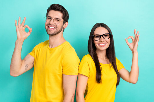 Photo promotion of two young man wife showing okey symbol wear yellow t-shirt stylish glasses recommend library isolated on blue color background - Powered by Adobe